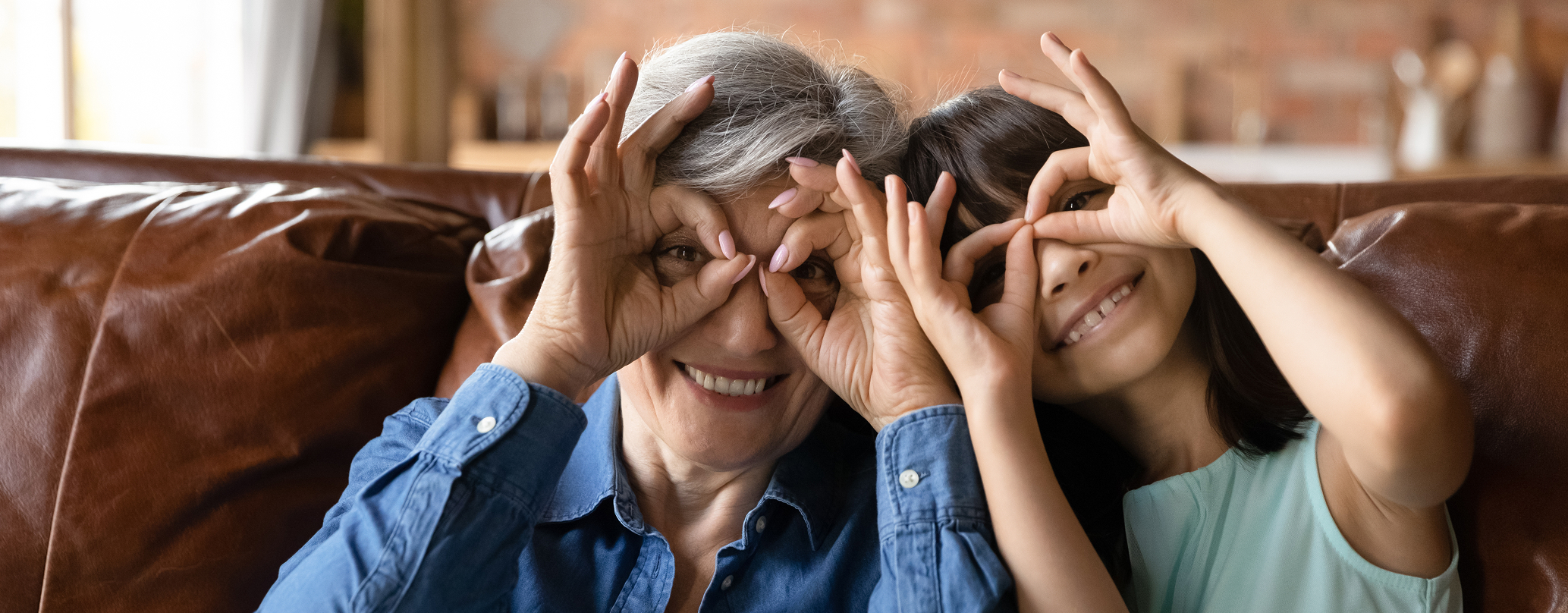A grandmother and granddaughter share a silly moment together, illustrating Laurel Oak Financial Advisor's commitment to communicating with people.